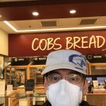 Sam has mask on when picking up bread